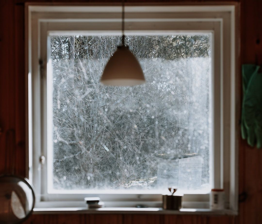 Vinterljus silas in genom ett fönster i ett träklätt rum